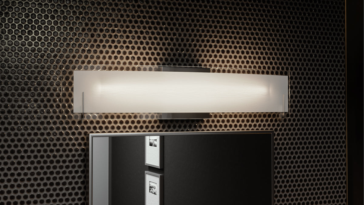 A modern linear vanity light showcased in a dimmed setting.