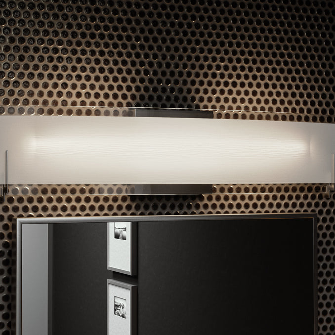 A modern linear vanity light showcased in a dimmed setting.